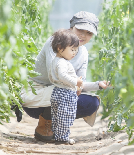 野菜を見ている子どもと見守る大人