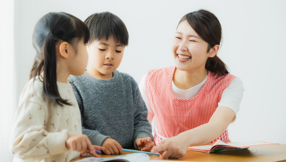 子どもに勉強を教える保育者